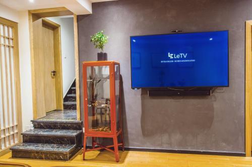 a flat screen tv on a wall next to a staircase at Han Xuan Boutique Hostel in Hangzhou