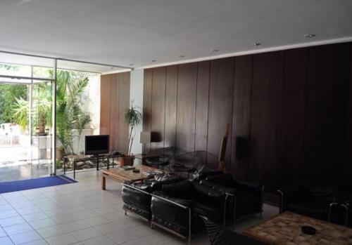 uma sala de estar com um sofá e uma televisão em Miami Hotel em Mati