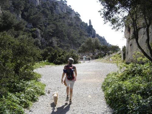 a woman walking a dog on a gravel road at Cairenou Location in Saint-Martin-dʼArdèche