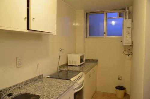 a small kitchen with a sink and a microwave at Apartamento Gutierrez in Mendoza