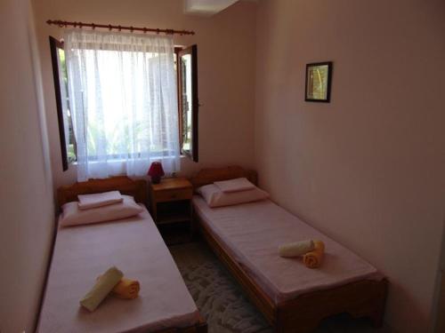 two twin beds in a room with a window at Apartman Sucuraj in Sućuraj