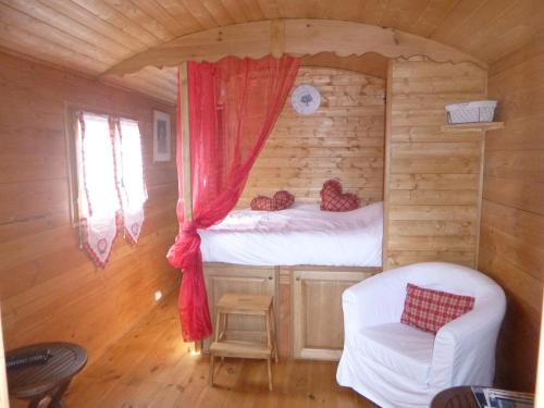 a bedroom in a log cabin with a bed and a chair at Le Mas Saint Donat in Sainte-Maxime