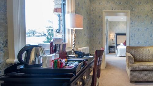 a room with a desk with a lamp and a chair at The Petersham in Richmond upon Thames