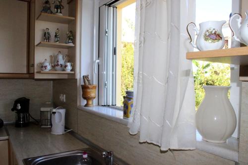 a window in a kitchen with a vase on a window sill at Sofia Filoxenia House in Kalyves