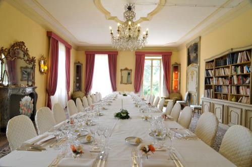 a long table in a room with chairs and a chandelier at Sina Villa Matilde in Romano Canavese