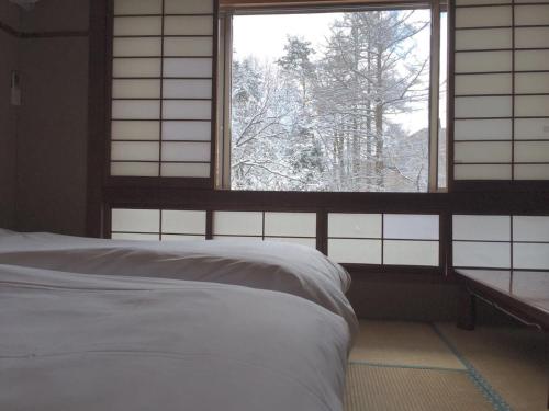 Un pat sau paturi într-o cameră la Hakuba Landmark Happo Lodge