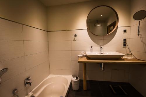 a bathroom with a sink and a tub and a mirror at Vergissmeinnicht in Oberhof