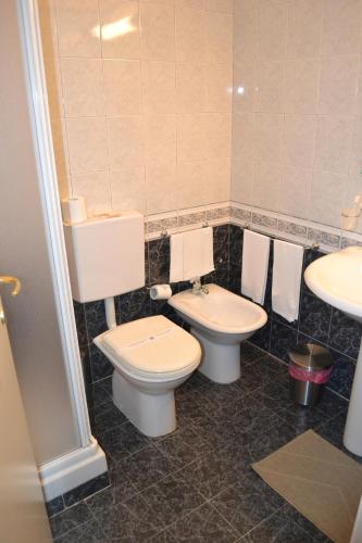 a bathroom with two toilets and a sink at Hotel Il Gatto in Rapallo