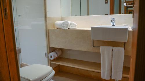 a bathroom with a sink and a toilet and a mirror at Hotel Atlântico Travel Copacabana in Rio de Janeiro