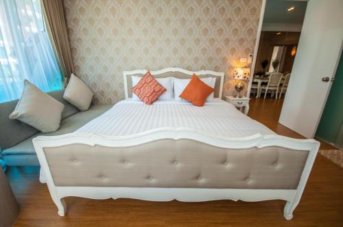 a white bed with orange pillows in a bedroom at My Resort Family Condo in Hua Hin