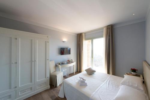 sypialnia z białym łóżkiem i oknem w obiekcie Agriturismo Fattoria di Monticello w mieście San Venanzo