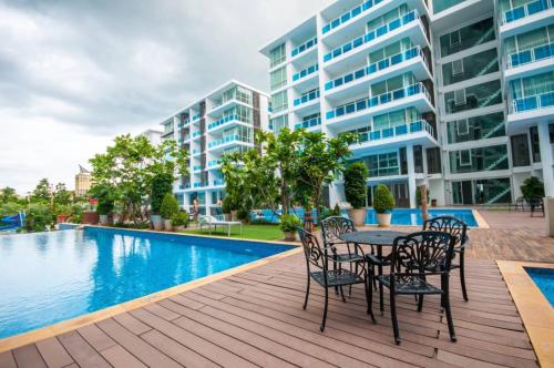 an apartment patio with a table and chairs next to a swimming pool at My Resort Family Condo in Hua Hin
