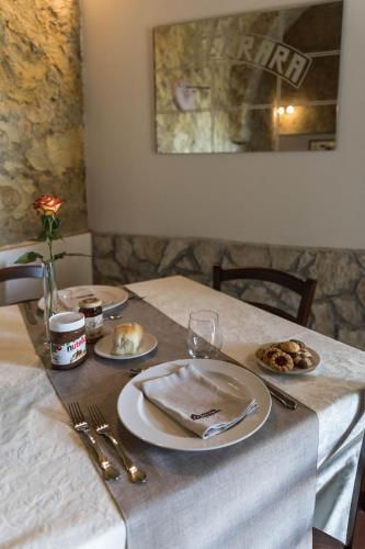 a table with plates and utensils on top of it at Tenuta Ferrara in Altavilla Silentina