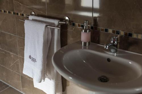 a bathroom with a sink and towels on a wall at Tenuta Ferrara in Altavilla Silentina