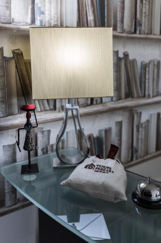 a lamp on a glass desk with a book shelf at Tenuta Ferrara in Altavilla Silentina