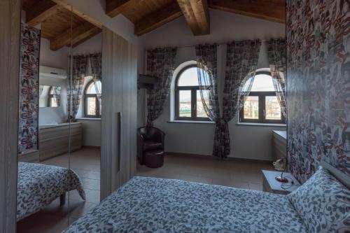 a bedroom with a bed and two windows at Tenuta Ferrara in Altavilla Silentina