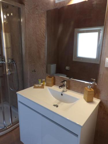 a bathroom with a white sink and a shower at Apothiki House in Kato Korakiana