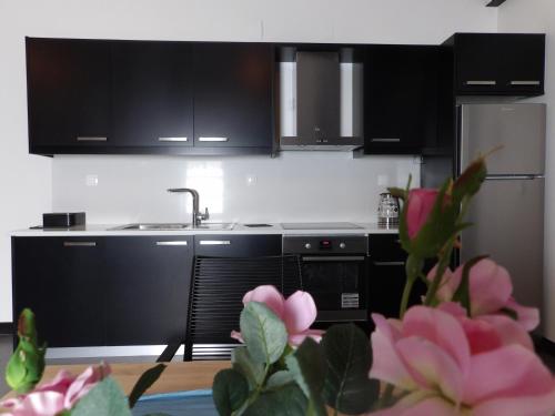 a kitchen with black cabinets and a sink at Apothiki House in Kato Korakiana