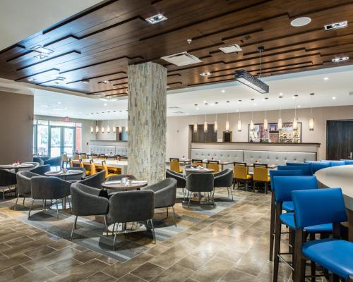 a restaurant with tables and chairs and a lobby at Cambria Hotel McAllen Convention Center in McAllen