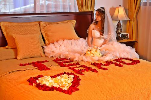 a woman in a wedding dress sitting on a bed at Hotel Yanuncay in Cuenca