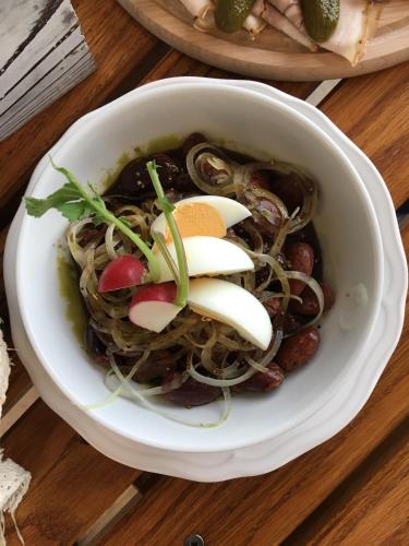 a bowl of food with onions and mushrooms on a table at Samenkönig Pschait Handels GmbH in Gamlitz