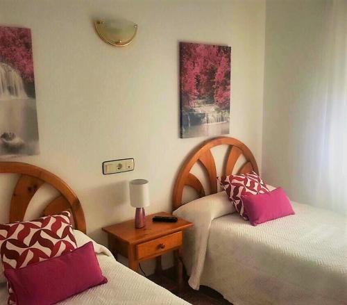 a bedroom with two beds and a table with a lamp at Las Cadenas in Ledesma