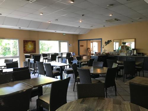 een eetkamer met tafels en stoelen bij Kyriad Direct Agen in Castelculier