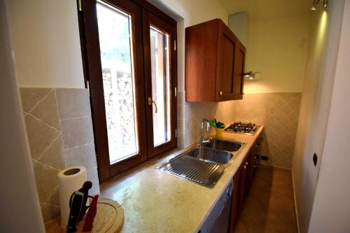 uma cozinha com um lavatório e uma janela em Dolci Colline em Schifanoia