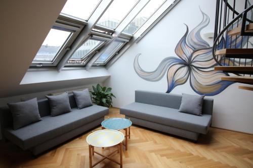 a living room with two couches and a staircase at aeki CITY in Vienna