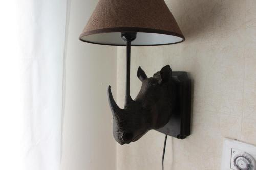 a rhino head hanging on a wall next to a lamp at DesertB in Giv'ot Bar