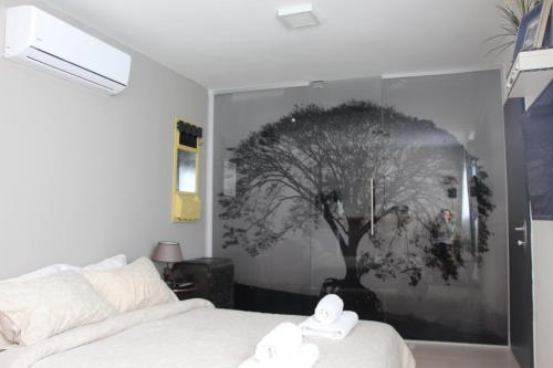 a bedroom with a picture of a tree on the wall at DesertB in Giv'ot Bar