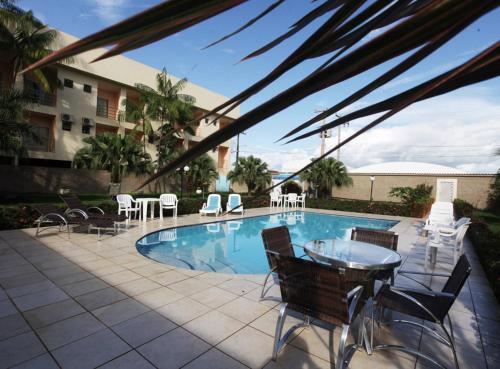 een zwembad met stoelen en een tafel en een patio bij Augustu's Hotel in Altamira