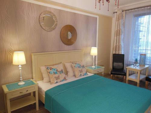 ママイアにあるGabrielle Apartmentのベッドルーム(青いベッド、ランプ2つ、テレビ付)