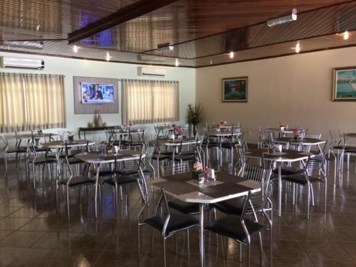 a restaurant with tables and chairs in a room at Augustu's Hotel in Altamira