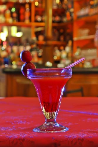 a martini glass with a cherry on a red table at Hotel Yanuncay in Cuenca