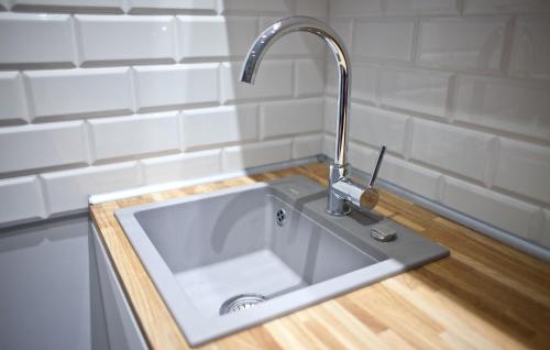 ein Waschbecken in einer Küche mit einem Wasserhahn in der Unterkunft Euro Apartments Piwna in Danzig