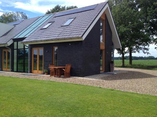 a black house with a picnic table in front of it at Het Klavertje in Laren