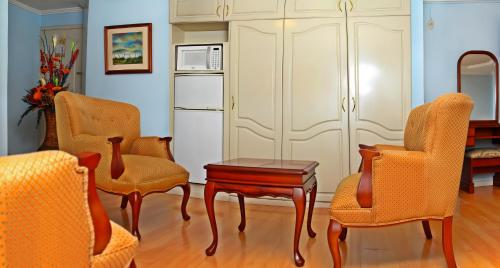 a living room with chairs and a table at Hotel Yanuncay in Cuenca