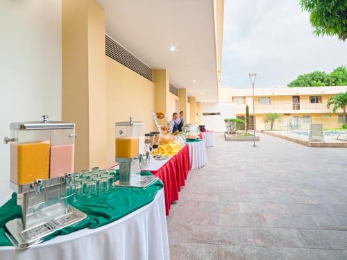 a group of tables with red and green table cloth at Hotel Arizona Suites Cúcuta in Cúcuta