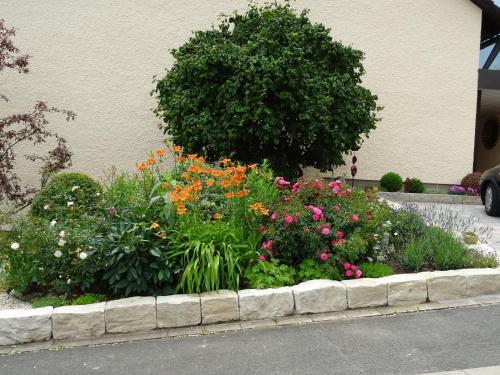 a garden of flowers in front of a building at Ferienwohnung Klaus in Ebermannstadt