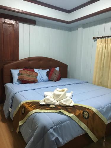 a bedroom with a bed with towels on it at บ้านเรือนไท มวกเหล็ก Ban Ruenthai MuakLek in Muak Lek District