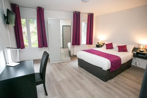 a bedroom with a large bed with red curtains and a desk at Grand Hotel De France in Meyrueis