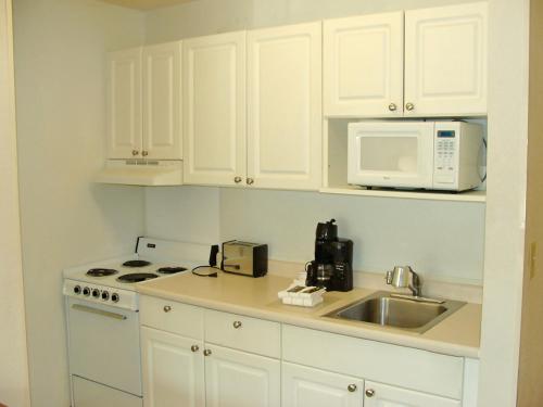 a kitchen with white cabinets and a sink and a microwave at Extended Stay America Suites - Pittsburgh - Airport in Imperial