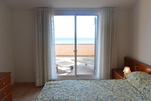 - une chambre avec un lit et une vue sur la plage dans l'établissement Apart Port Pals Duplex, à Pals