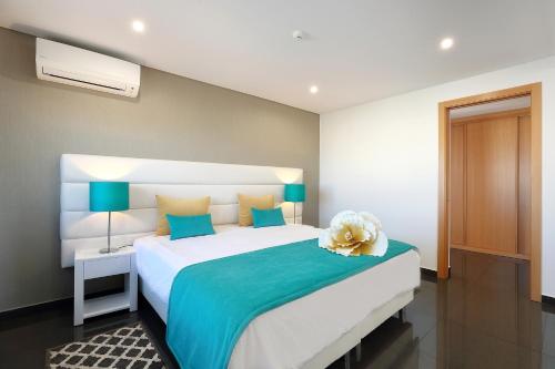 a bedroom with a bed with a teddy bear on it at Sunfield Guest House - Only Adults in Albufeira