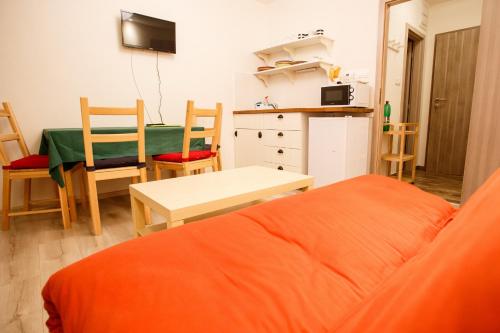 a room with a bed and a table and a kitchen at Apartments Pod Kotlom in Vysoké Tatry
