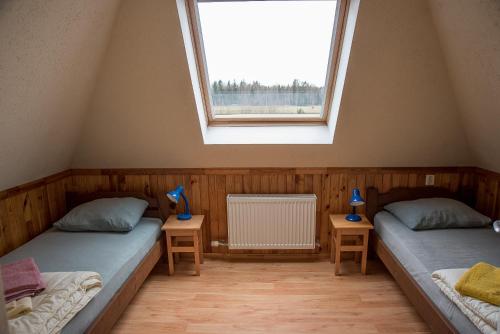 two twin beds in a room with a window at Fox House in Pelči