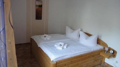 um quarto com uma cama de madeira e toalhas em Kumm Wedder em Insel Poel