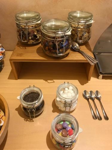 a wooden shelf with jars of eggs and spoons at Hotel Villa Merope in Rimini