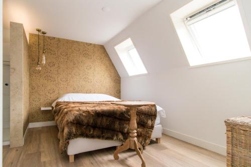 a bedroom with a bed with a blanket and a window at Short stay Midden Drenthe in Beilen